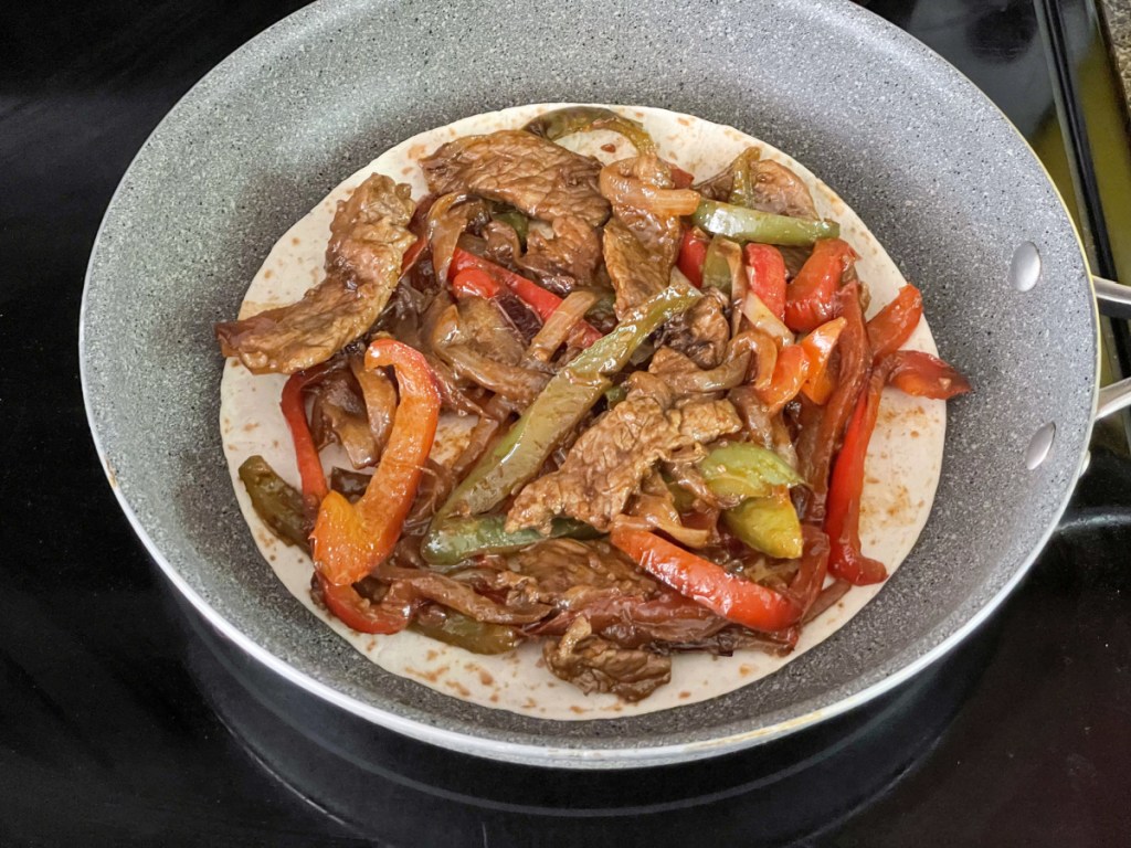 steak fajita on a torilla in a skillet