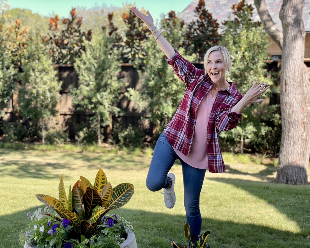 woman standing outside dancing in grass