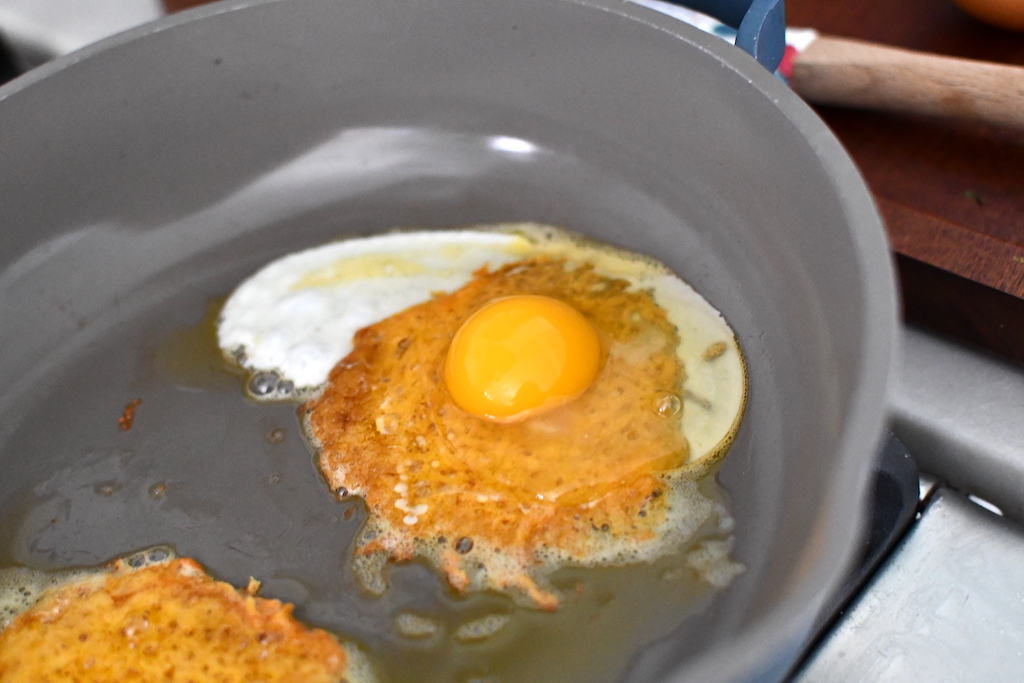 egg cooking on top of fried cheese