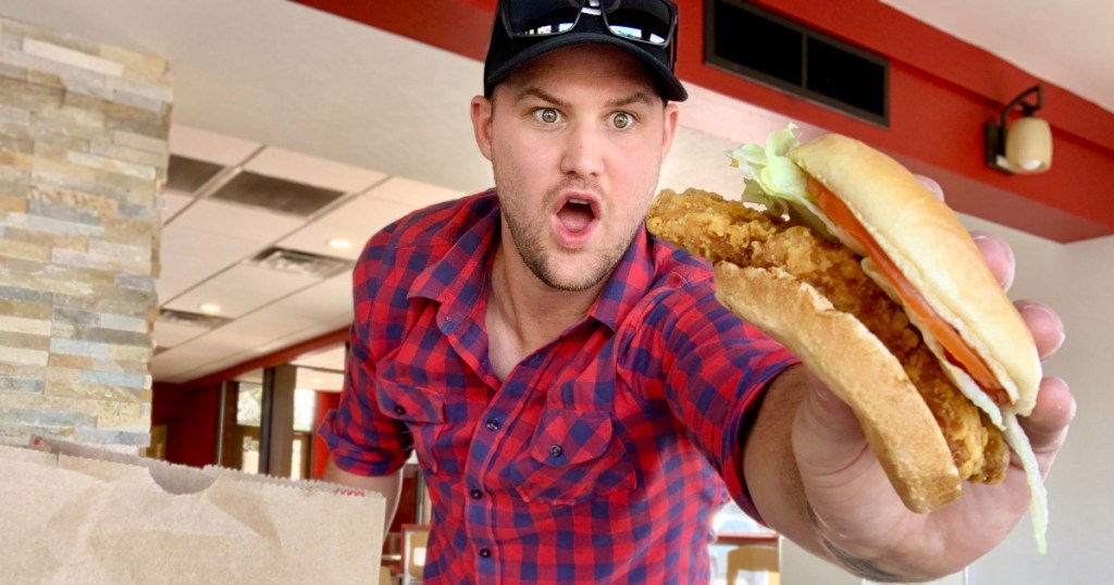 man holding fried chicken sandwich 