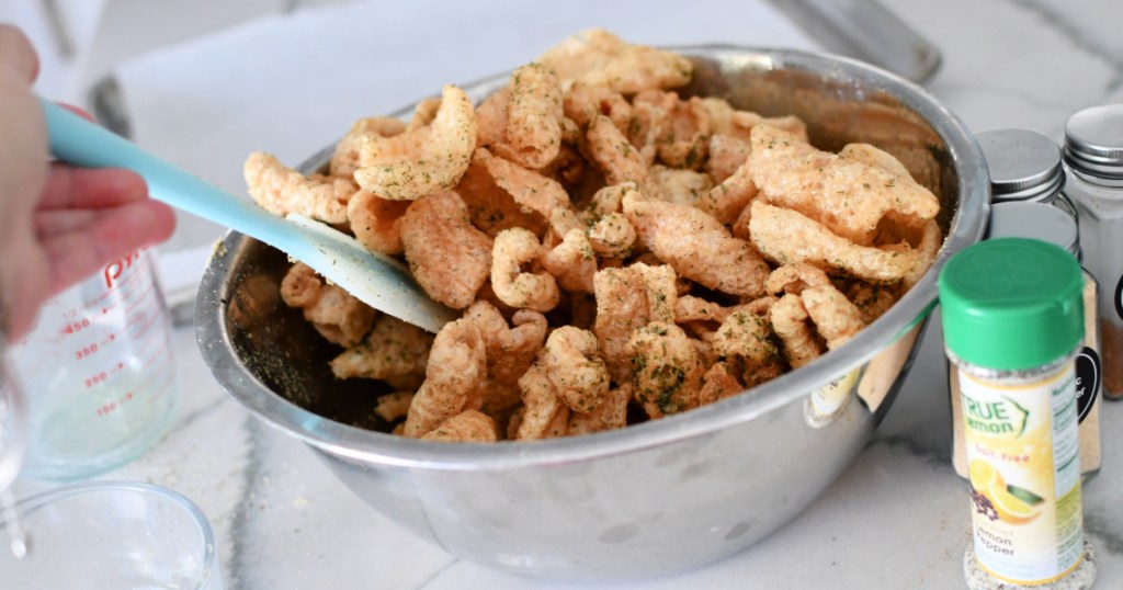 stirring pork rinds in a large bowl