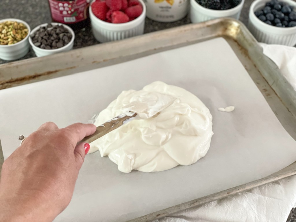 spreading yogurt on baking sheet