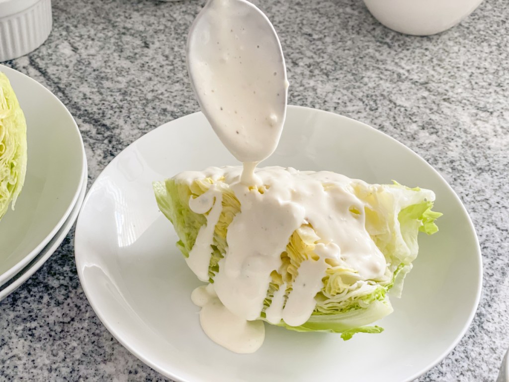 putting blue cheese dressing on an iceberg wedge