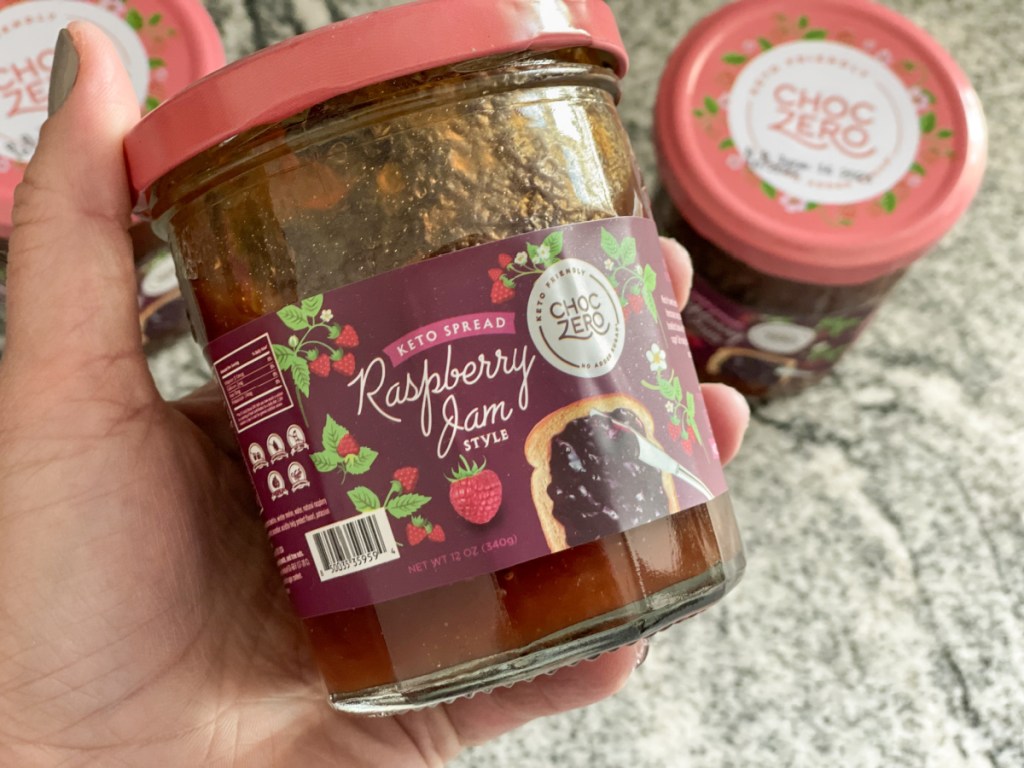 holding jar of choczero keto raspberry jam