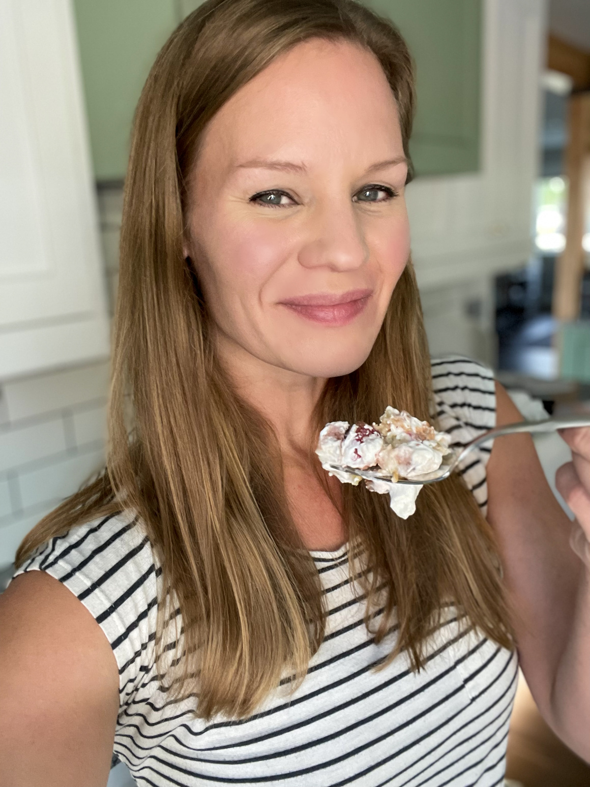 woman taking bite of keto raspberry trifle