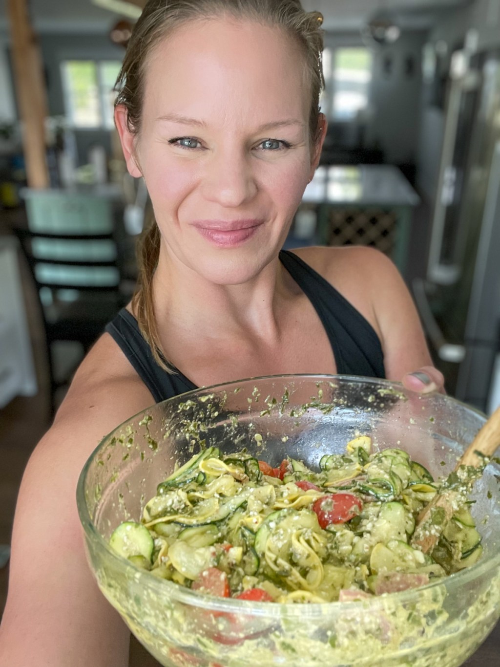 woman holding bowl of zucchini salad