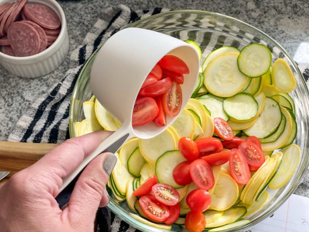 adding tomatoes to bowl