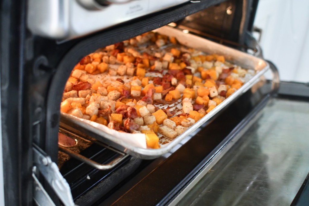 sheet pan with jicama and butternut squash with bacon in the oven