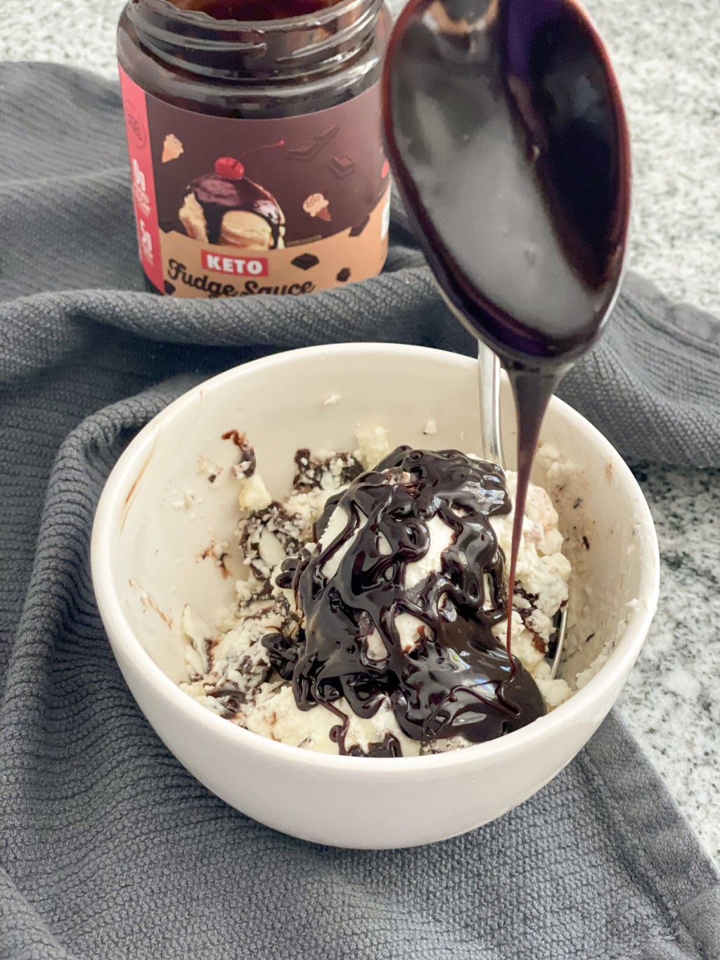 putting choczero keto hot fudge sauce on keto ice cream