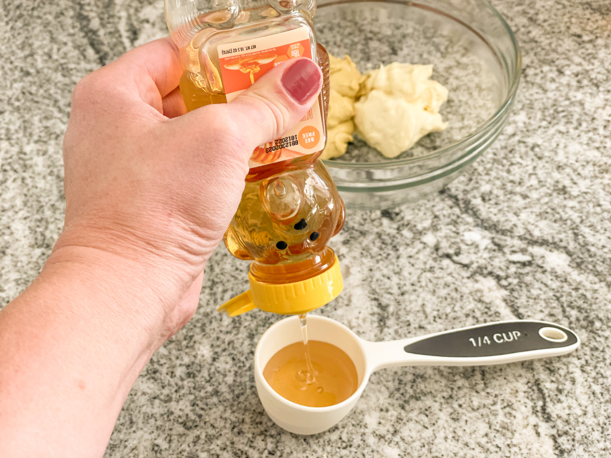 squeezing keto honey into bowl