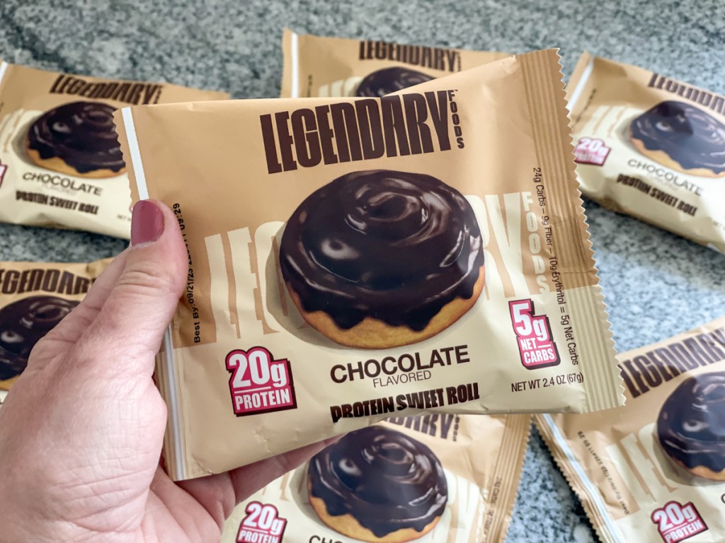 holding legendary foods protein chocolate sweet roll in package