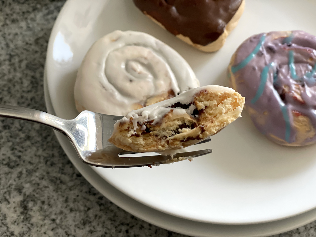 taking a bite of Legendary Foods sweet rolls 