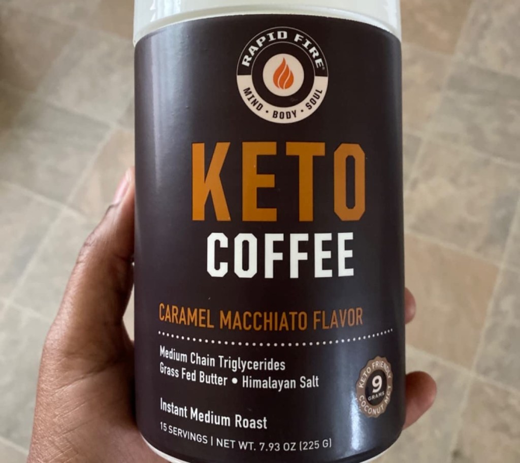 holding a canister of powdered keto coffee mix