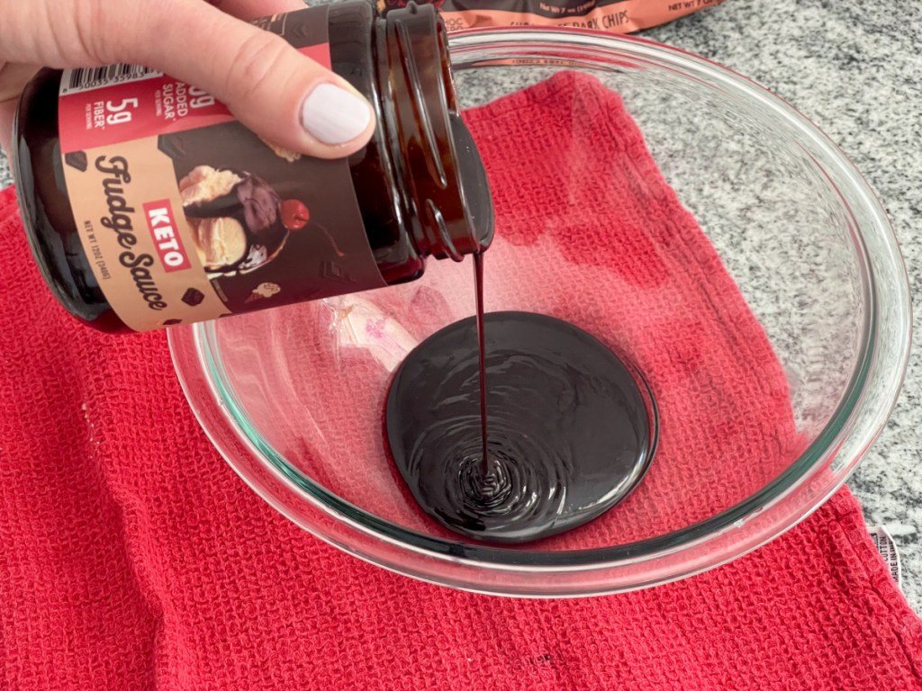 pouring choczero hot fudge into a bowl