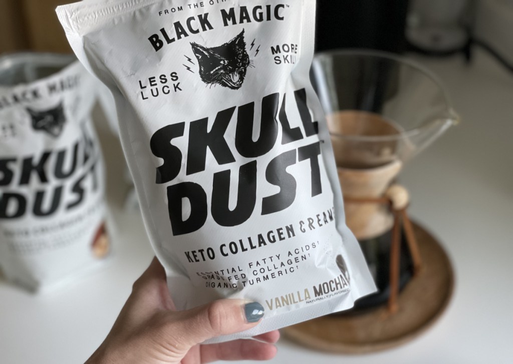 Hand holding a bag of Black Magic Skull Dust Keto Collagen Creamer