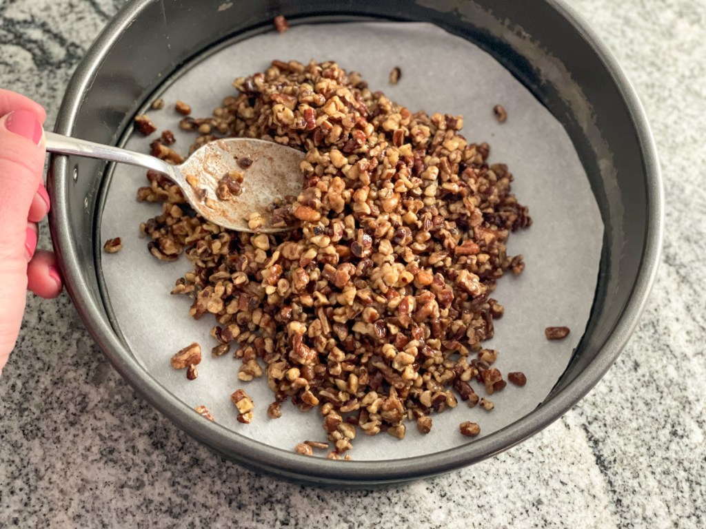pecans mixed with butter in springform pan