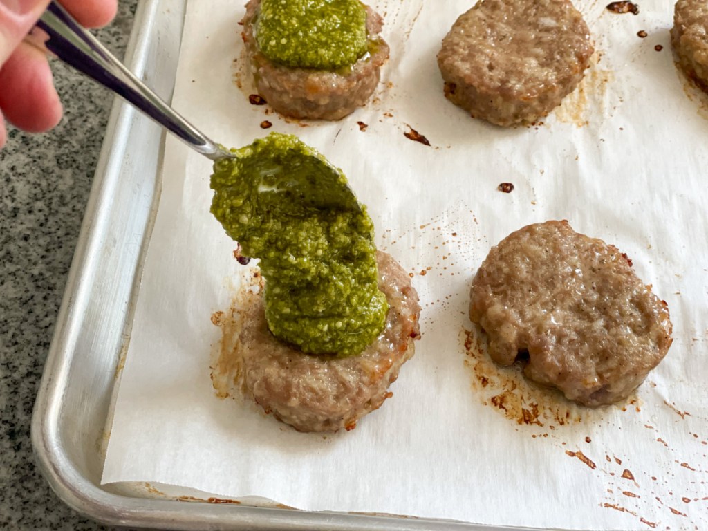 putting pesto on sausage patties