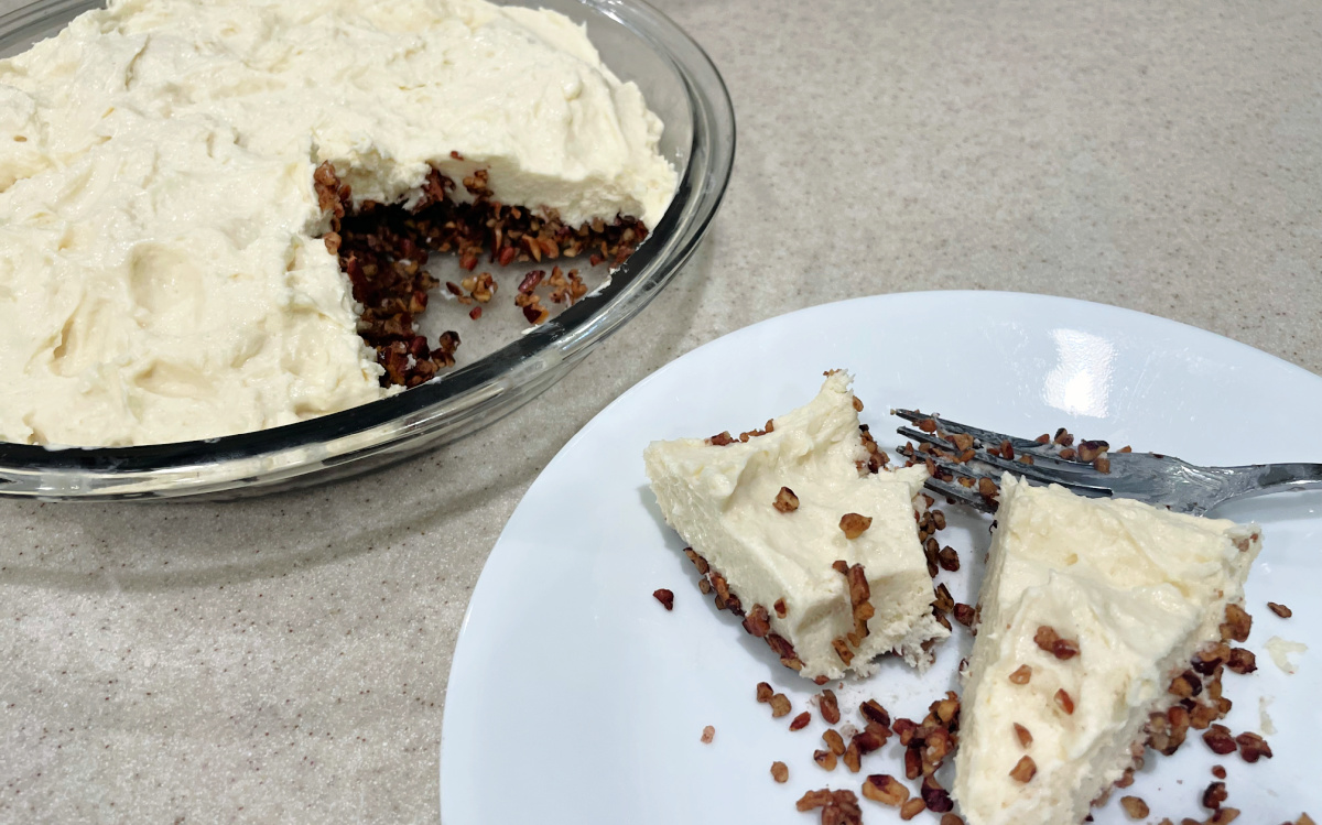 pie dish with keto no bake cheesecake and slice on plate