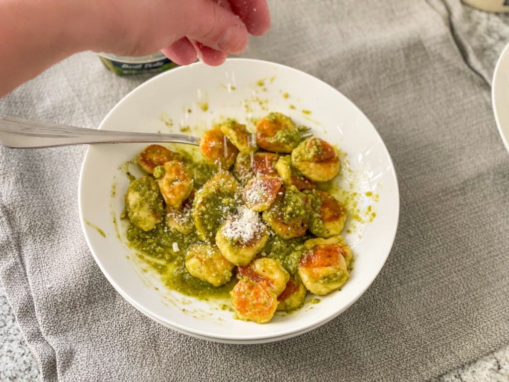 sprinkling parmesan over keto gnocchi recipe