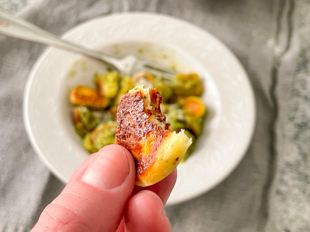 holding a keto gnocchi with a bite out of it