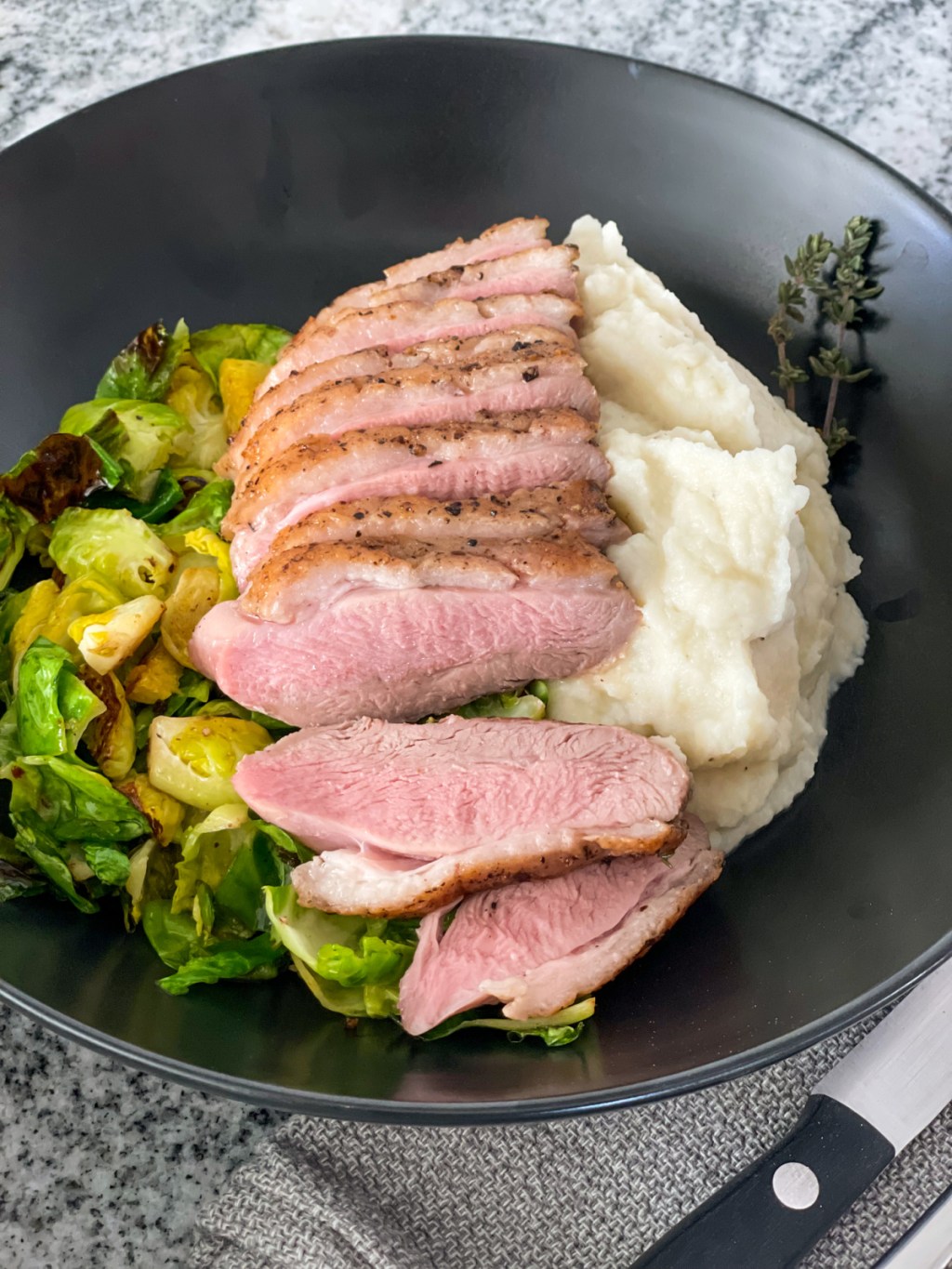 plated duck breast with mashed cauliflower and Brussels sprouts