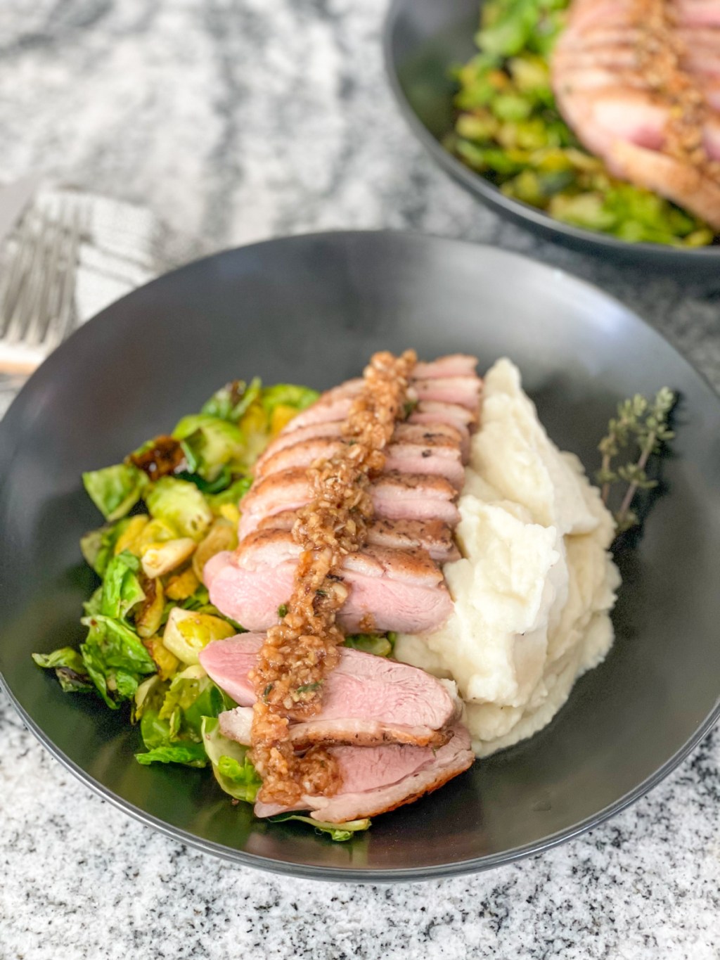 plated easy duck breast recipe with mashed cauliflower and Brussels sprouts