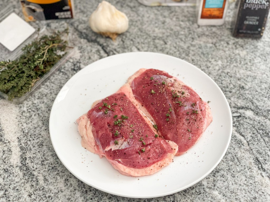 raw duck breasts seasoned on a plate