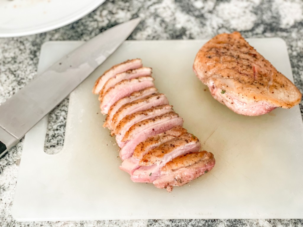sliced cooked duck breast on a cutting board