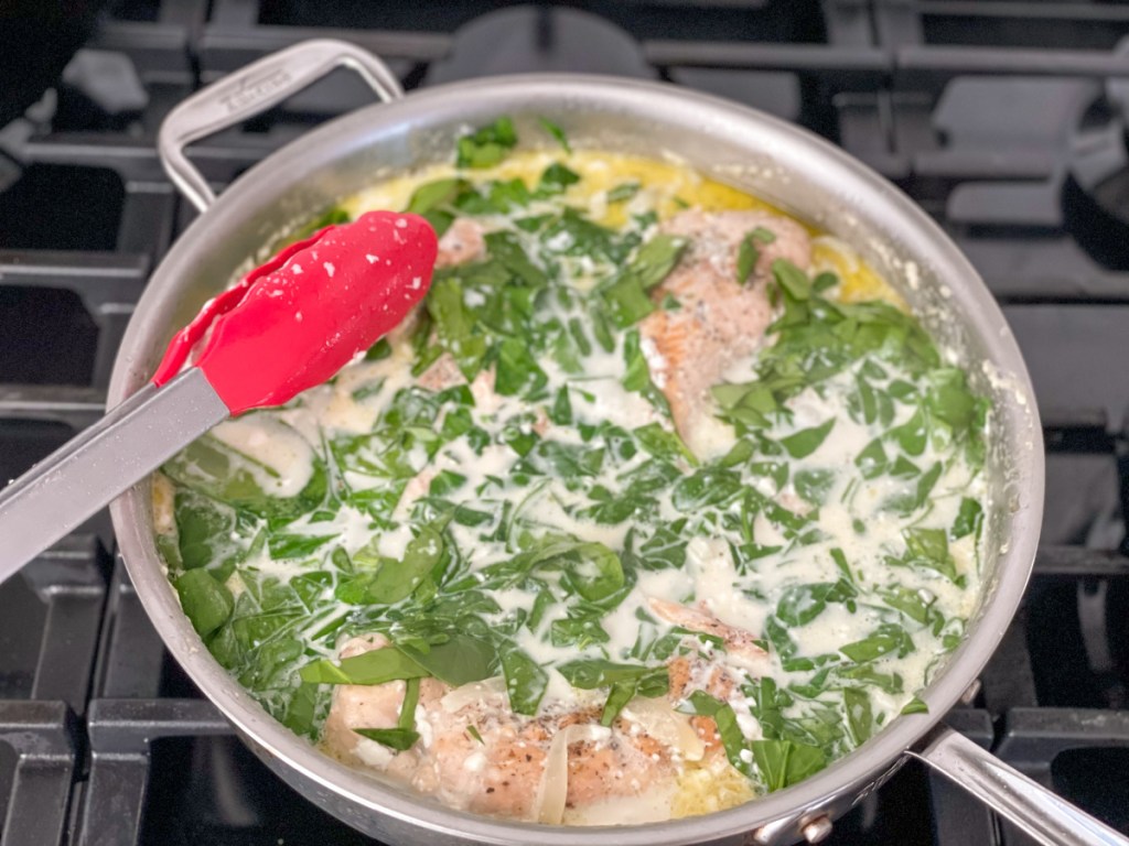 spinach in a skillet with chicken and a cream sauce 