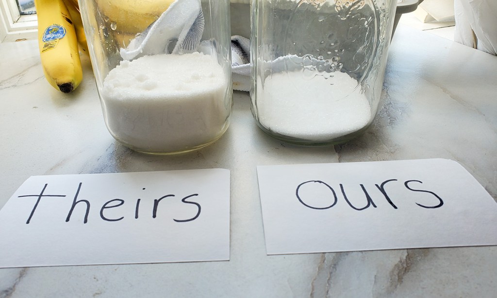 mason jars with sugar showing the comparison between sugar in original banana bread versus keto banana bread