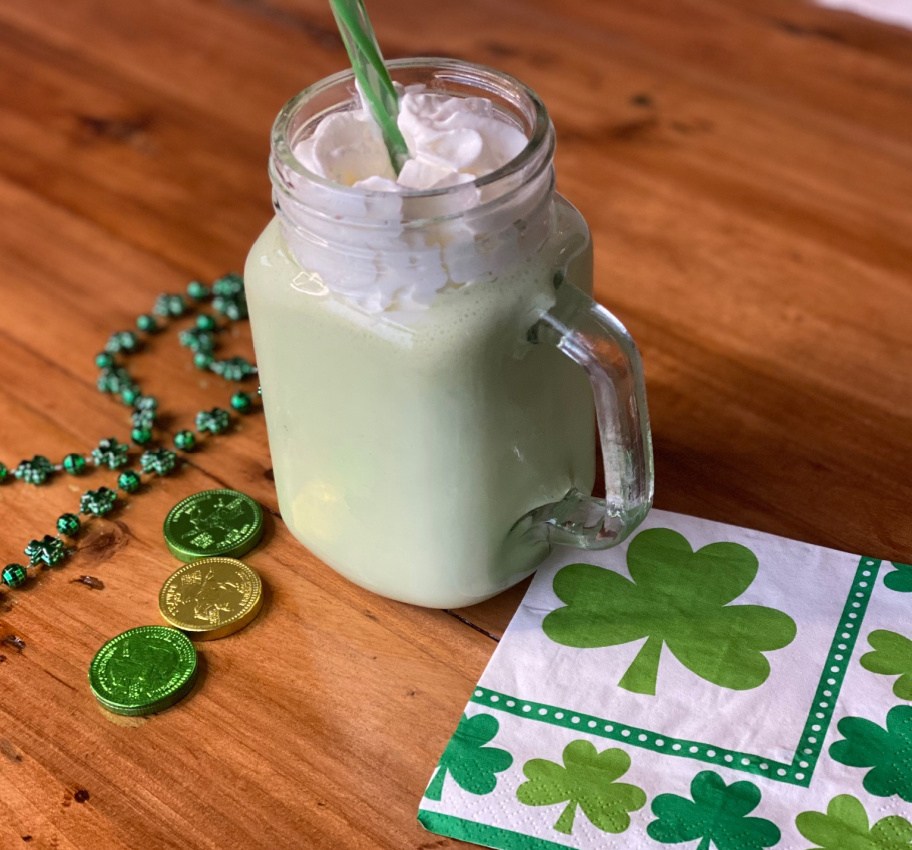 A keto shamrock shake milkshake on a table next to St. Patrick's Day napkins