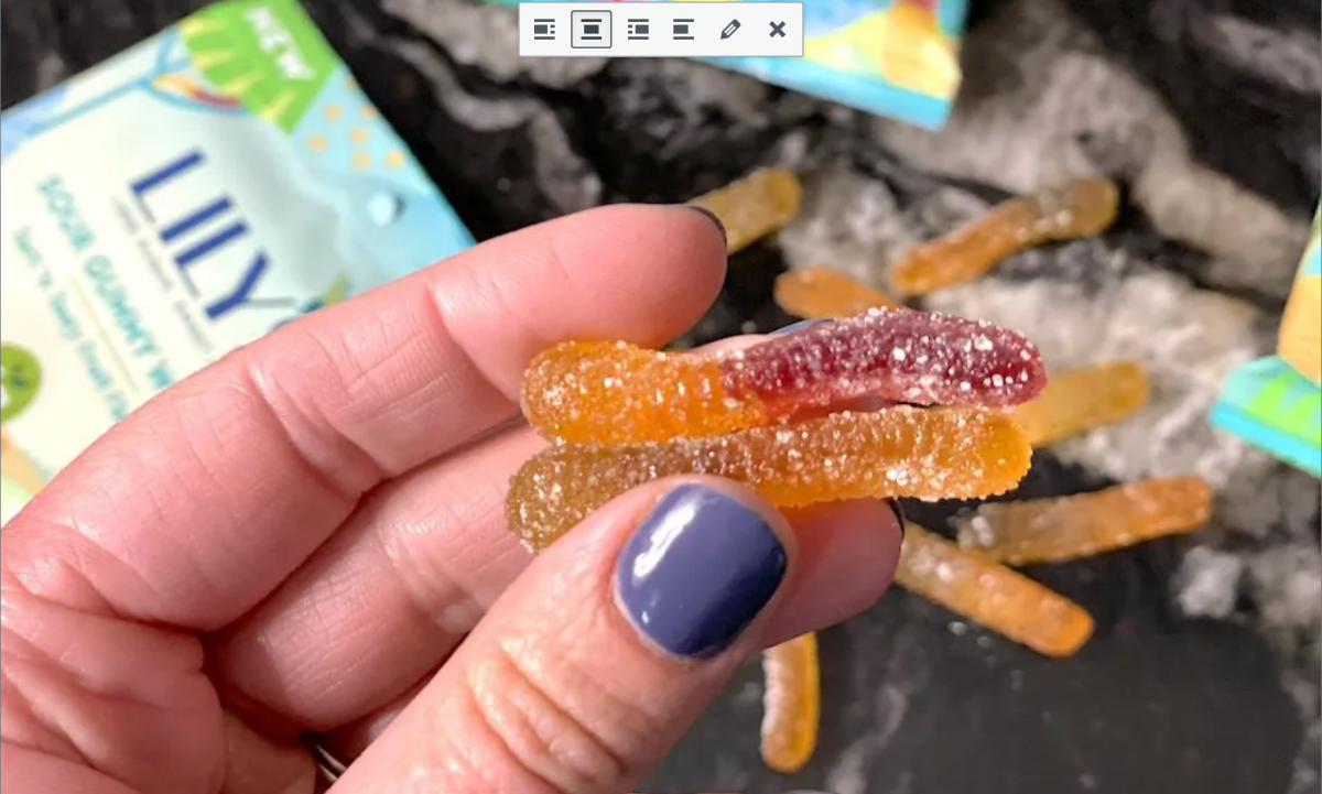 A hand holding Lily's gummy worms, one of the best keto candy options 