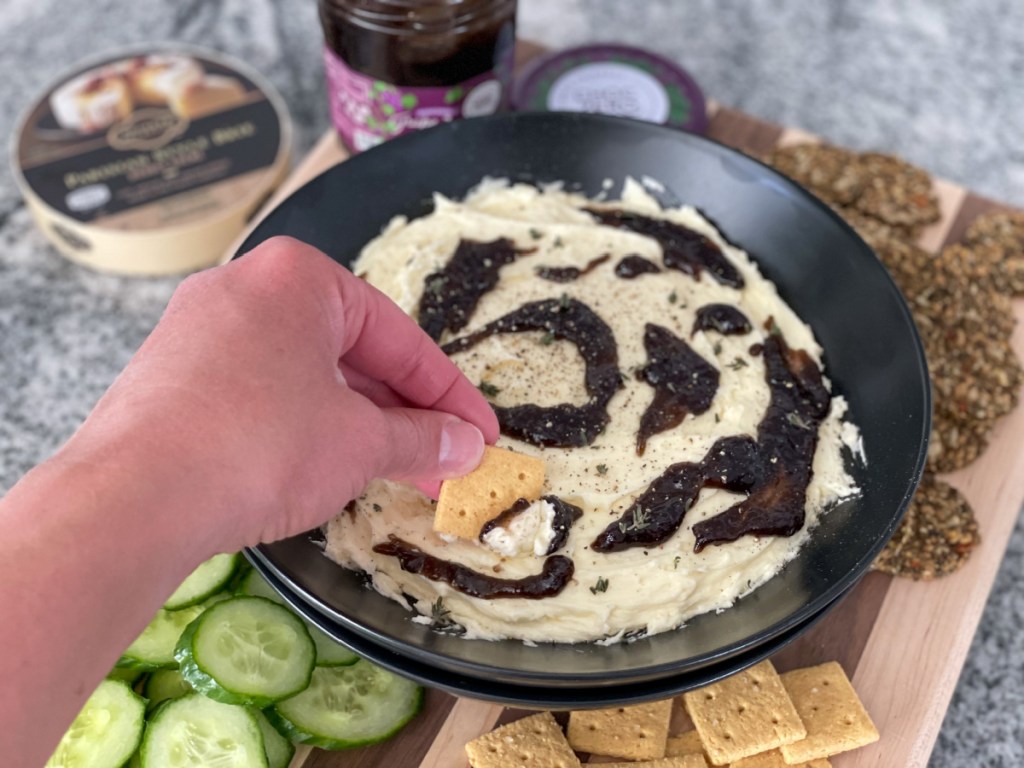 dipping a cracker into whipped keto brie