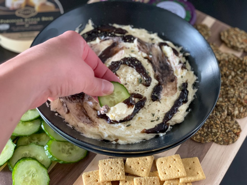 dipping a cucumber slice in whipped keto brie