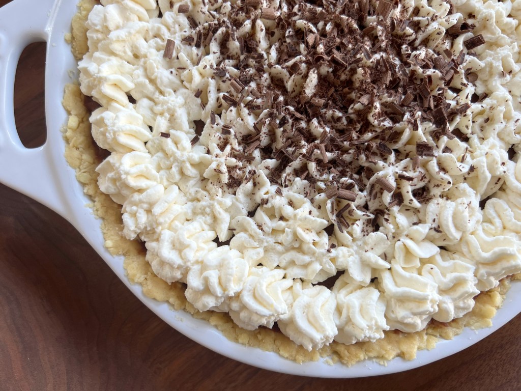 Close up of chocolate cream pie with whipped cream and chocolate shavings