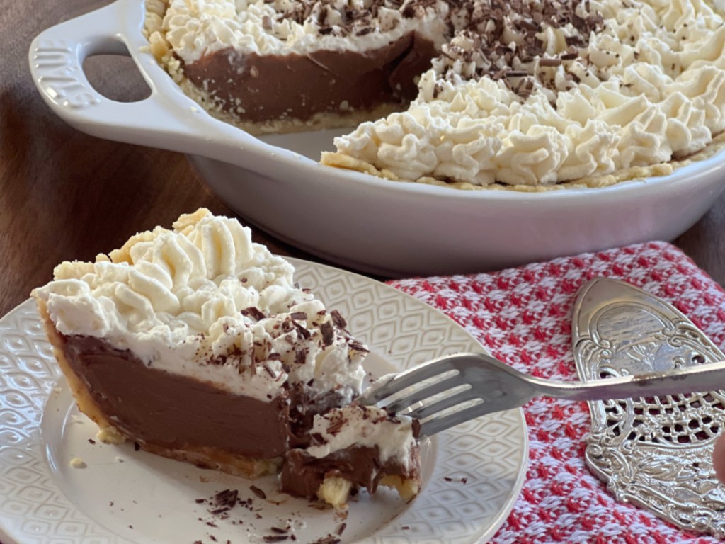 A fork cutting into a slice of keto chocolate cream pie