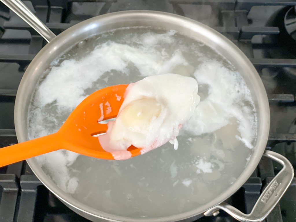 poached egg in a slotted spoon