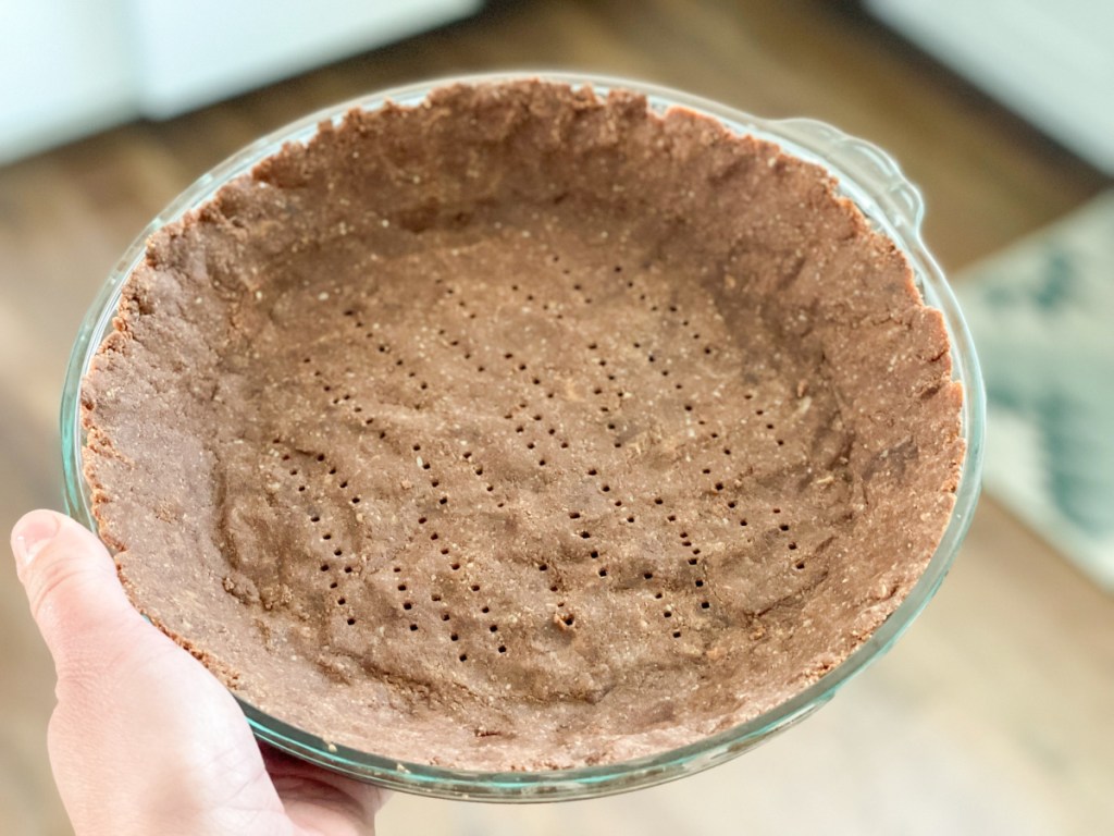 holding a chocolate keto pie crust