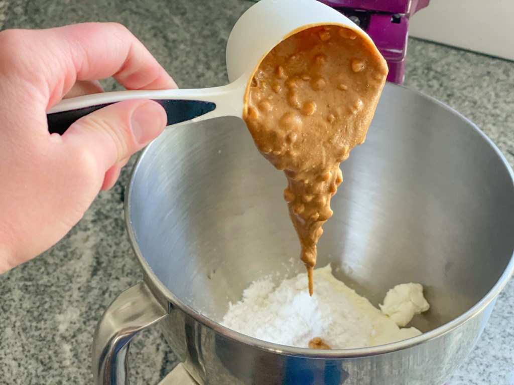 adding peanut butter to a mixing bowl
