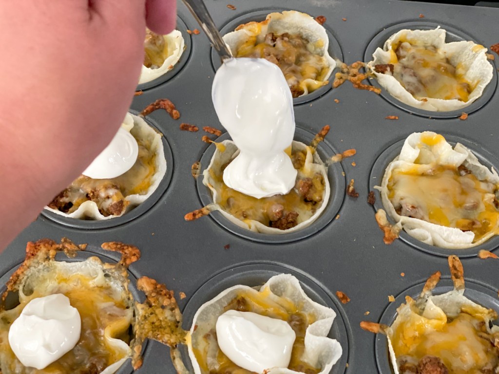 topping keto taco cups with sour cream