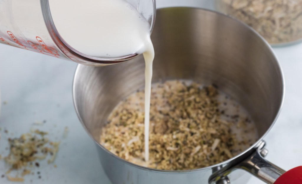 Pouring milk into a saucepan to make a keto oatmeal recipe