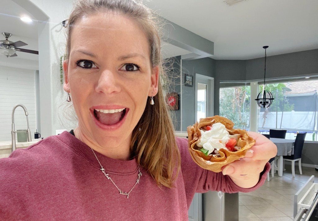 woman holding keto taco cup in kitchen