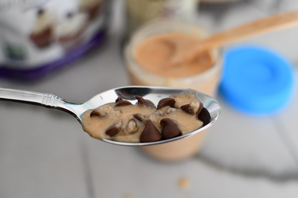 holding spoon with coconut butter and chocolate chips 