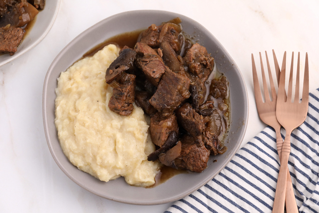 beef tips in bowl with mashed cauliflower 