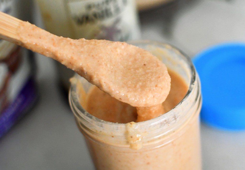 keto coconut butter on spoon coming out of jar