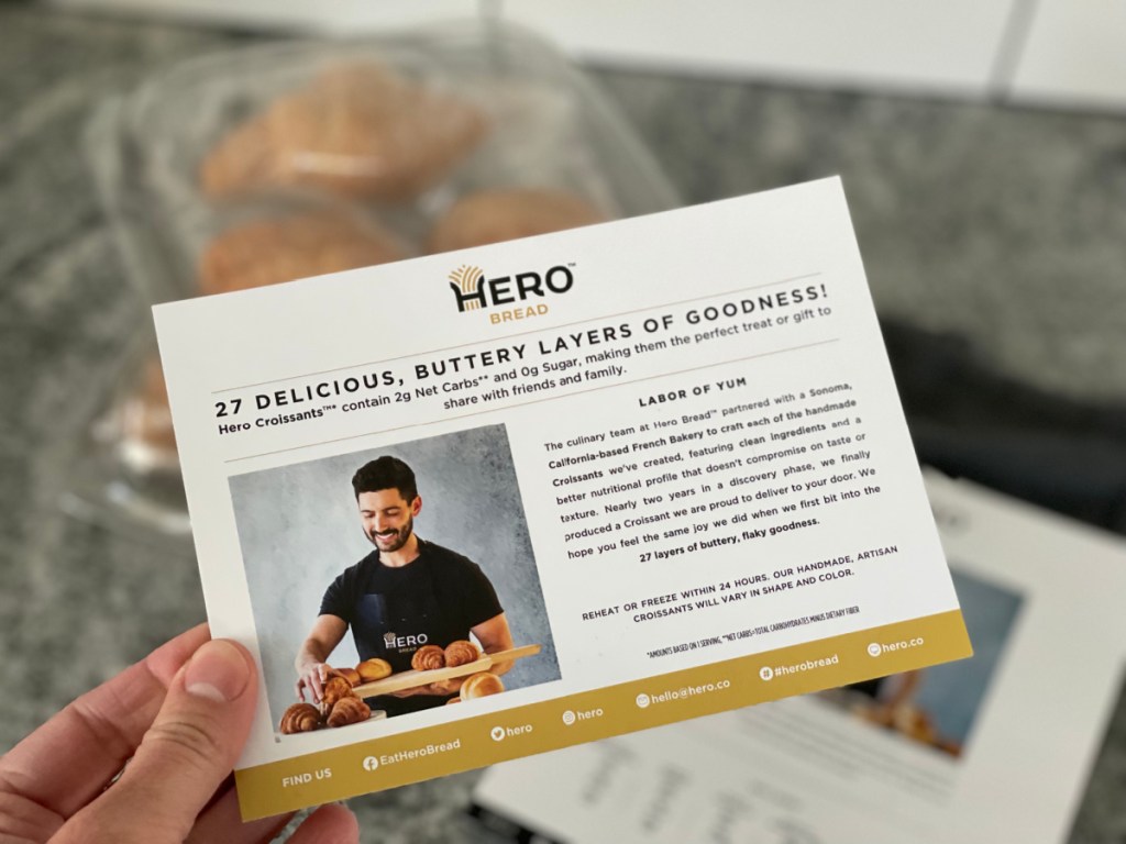Hand holding a flyer with Hero Bread Croissant Information
