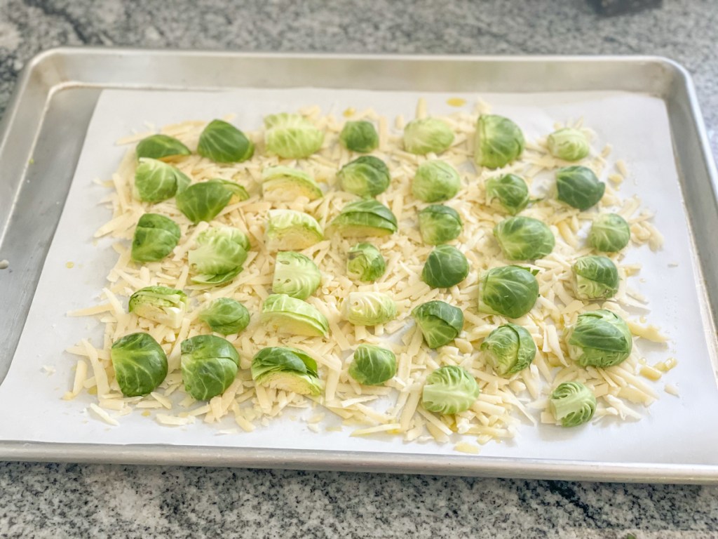 shredded parmesan and Brussels sprouts on a baking sheet