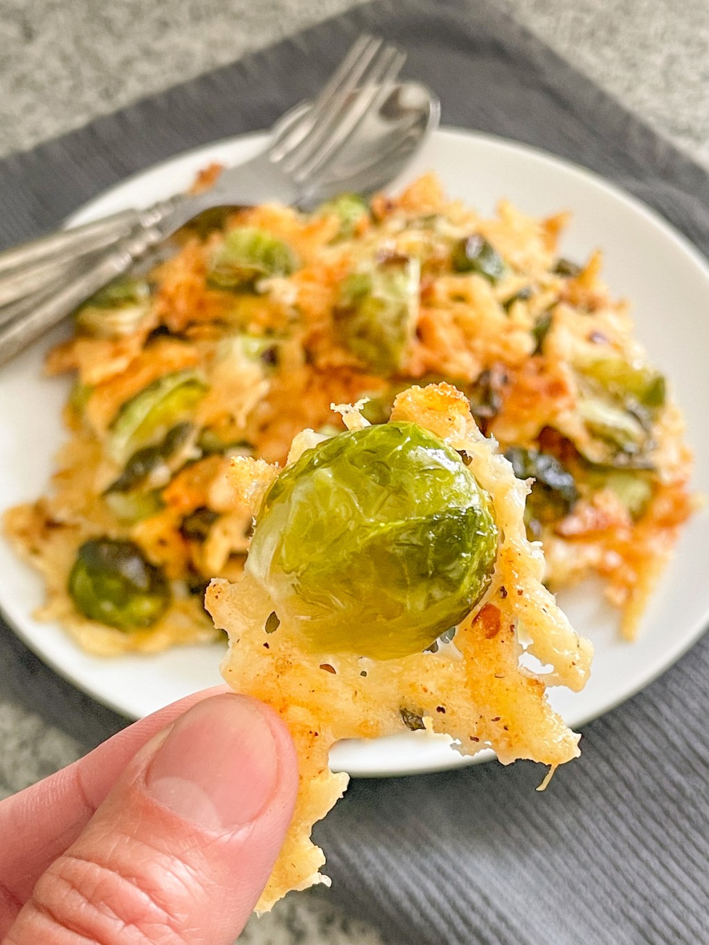 holding a crispy keto parmesan brussels sprout