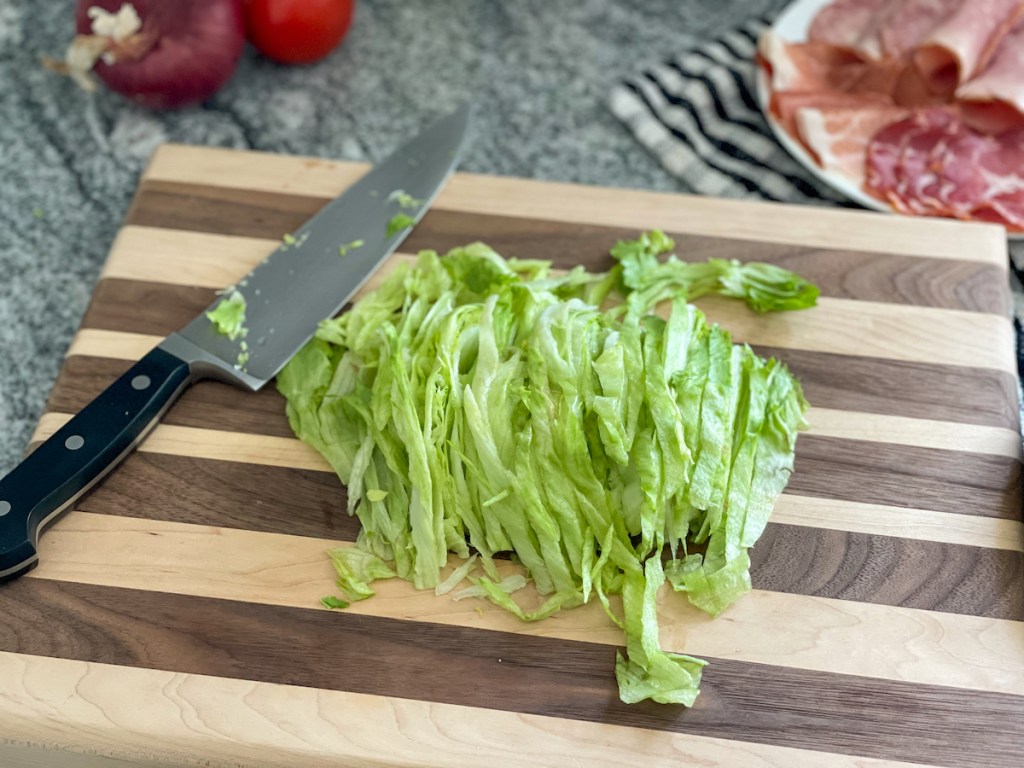 iceberg lettuce thinly sliced on a cutting board