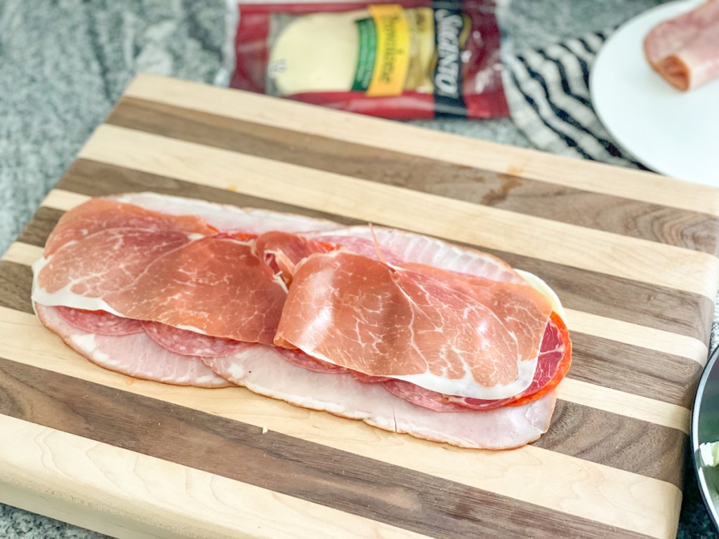 provolone, ham, salami, pepperoni, capocollo, and prosciutto on a cutting board